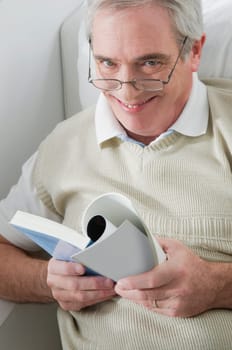 Portrait of a senior man holding a book and smiling