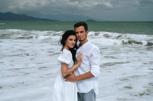 happy couple in love hugs on the beach by the sea in summer on vacation