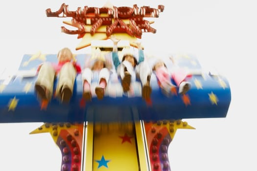 Low angle view of boys and girls on an amusement park ride