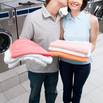 Man kissing a woman in a laundromat