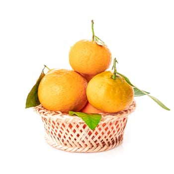 tangerines  with leaves in a beautiful basket. organic ripe mandarins
