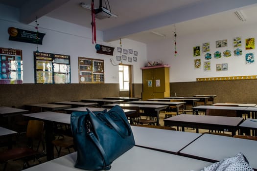 Classroom without students or children and only a purse on the teacher's desk