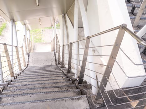 staircase for descending from footbridge. The concrete overpass for crossing the road.