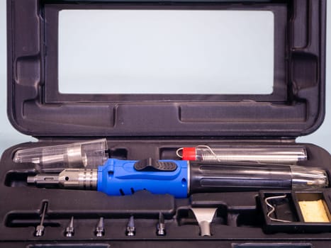 Gas soldering iron in black box isolated on white background.