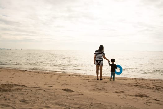 mother and son by on the sea