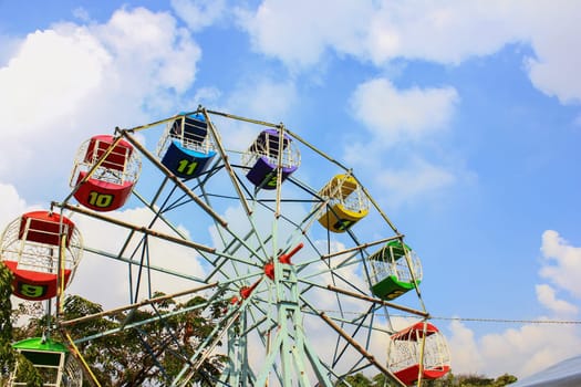 Children's carousel with colored booths against the blue sky