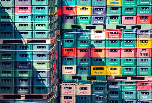 Containers with bottles of beer in warehouse. Rows of plastic crates.
