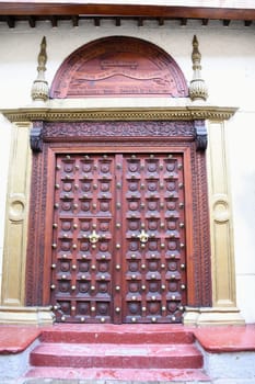 The famous and historic Indian style front doors adorn many houses in Stone Town on the island of Zanzibar. The Indian doors have a domed frame and brass tips.