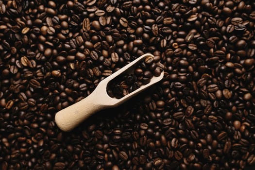 Background with array of dry coffee beans and spoon. High quality photo