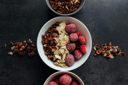 Frozen strawberry with granola, almond flakes on concrete table. High quality photo