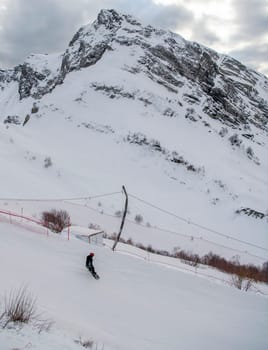 Sochi  Russia - January 02  2021: Snowboarder go downhill at the Krasnaya Polyana ski resort