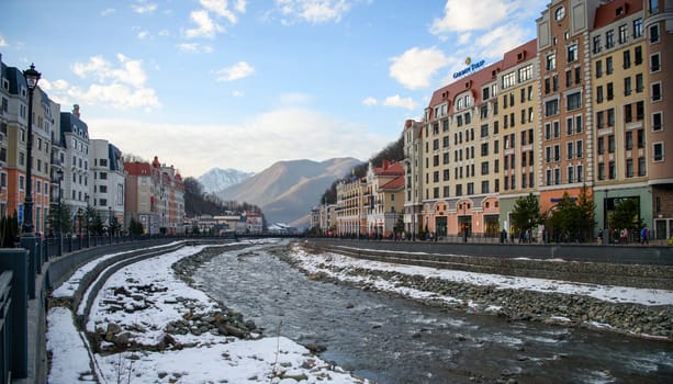 Sochi  Russia - January 02  2021: The Mzymta river in the Krasnaya Polyana resort. Tourists walk along the embankment