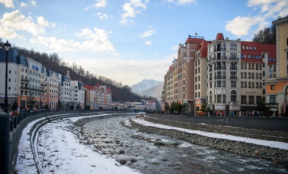 Sochi  Russia - January 02  2021: The Mzymta river in the Krasnaya Polyana resort. Tourists walk along the embankment