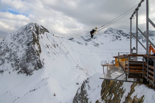 Sochi  Russia - January 02  2021: Tourists ride on the mega-swing of the Gorki Fly panoramic site at the Krasnaya Polyana ski resort