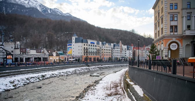 Sochi  Russia - January 02  2021: The Mzymta river in the Krasnaya Polyana resort. Tourists walk along the embankment