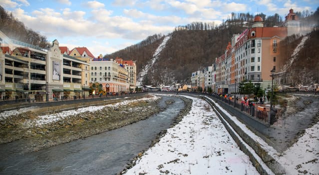 Sochi  Russia - January 02  2021: The Mzymta river in the Krasnaya Polyana resort. Tourists walk along the embankment