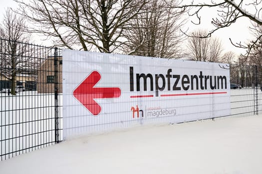 Directional arrow to a vaccination center on the outskirts of the city of Magdeburg in Germany. Sign with the inscription vaccination center