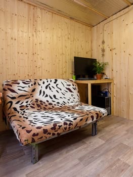 Fragment of the interior of a small living space, in the corner there is a computer table, next to a sofa