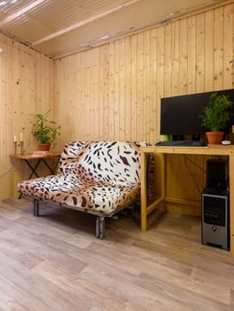 Interior of a country house room, next to the sofa is a computer desk