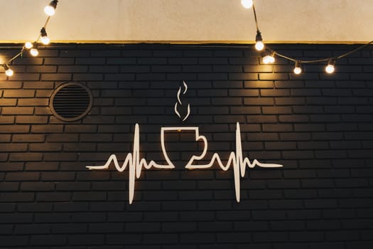 Coffee symbol on black brick wall with garlands. High quality photo