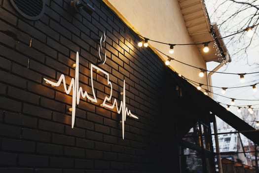 Coffee symbol on black brick wall with garlands. High quality photo