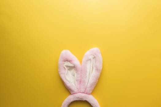 Pink Easter bunny ears on the yellow background. High quality photo