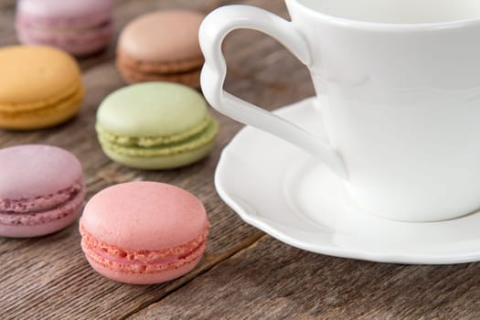 Macaroons on a wooden table with cup of coffee