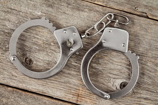 Top view of handcuffs on the wooden background