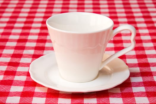 White cup on the checkered tablecloth texture