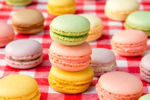 Traditional colorful french macaroons on checkered tablecloth