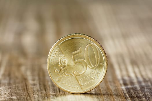 Extremely close up of fifty euro cent on the wooden surface