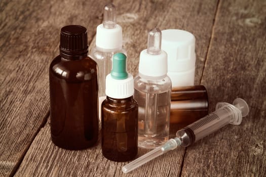 Pharmacy theme. Syringe and various medicaments on the wooden background