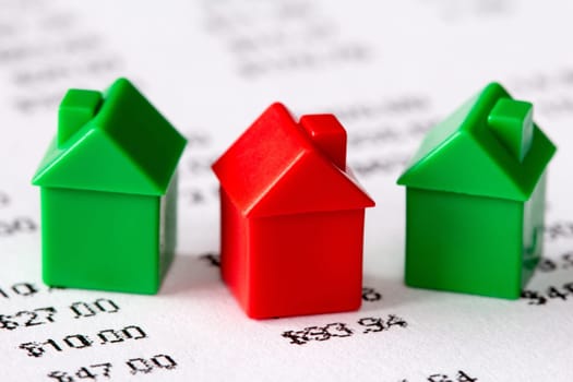 Green and red houses on a financial report background