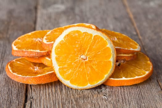 Slices of orange fruit on the wooden background