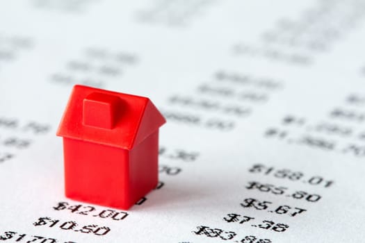 Red miniature house on a financial report background