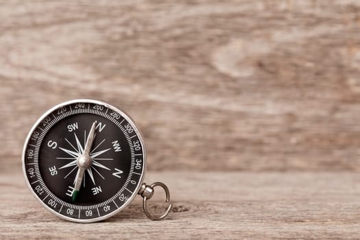 Magnetic compass on a wooden background. Concept of global travel , tourism and exploration.