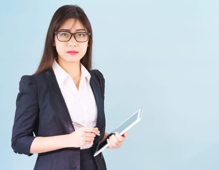 Young Asain women in suit standing using her digital tablet against blue background