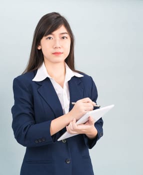 Asian woman in suit using computer digital tablet isolated on gray background