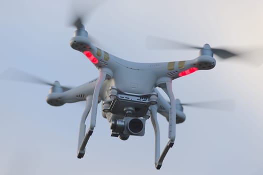 Great Malvern, United Kingdom, 27th December, 2020: Full frame close up front view of a hovering quadcopter camera drone. Plain sky background