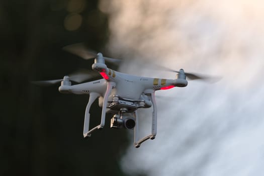 Great Malvern, United Kingdom, 27th December, 2020: Remote control quadcopter camera drone flying in the evening sky. Plain background and motion blur