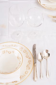 Wine glasses with plates and cutleries on a dining table