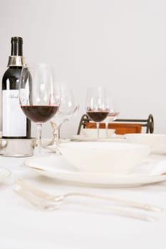 Wine bottle and wine glasses with tableware on a dining table