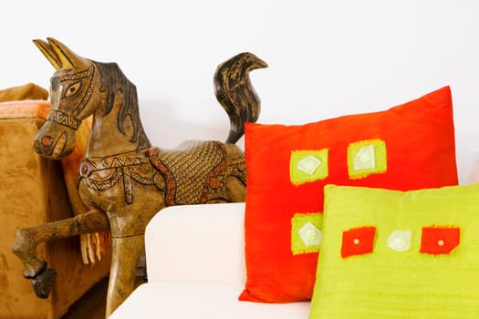 Close-up of cushions on a couch with a wooden horse