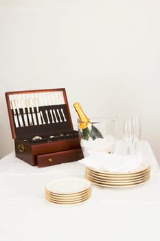 Cutlery box with a champagne bottle and tableware on a dining table
