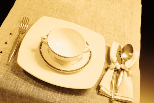 High angle view of a soup bowl with a plate on a dining table