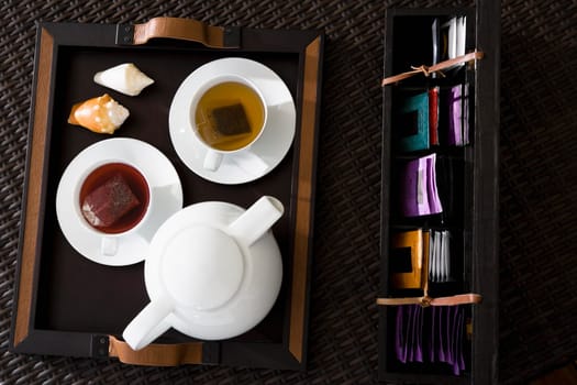 High angle view of cups of herbal tea with a teapot on a serving tray
