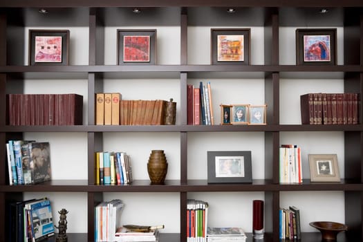 Books and picture frames in shelves