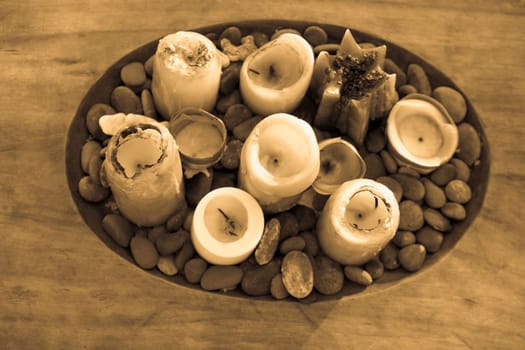 High angle view of candles and pebbles in a wooden tray