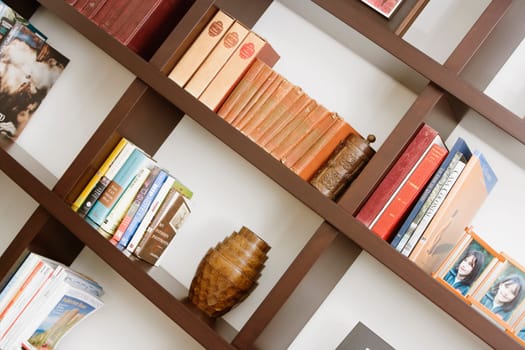 Close_up of books and picture frames in shelves