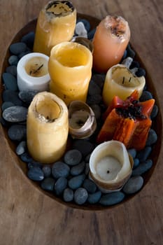 High angle view of candles and pebbles in a wooden tray
